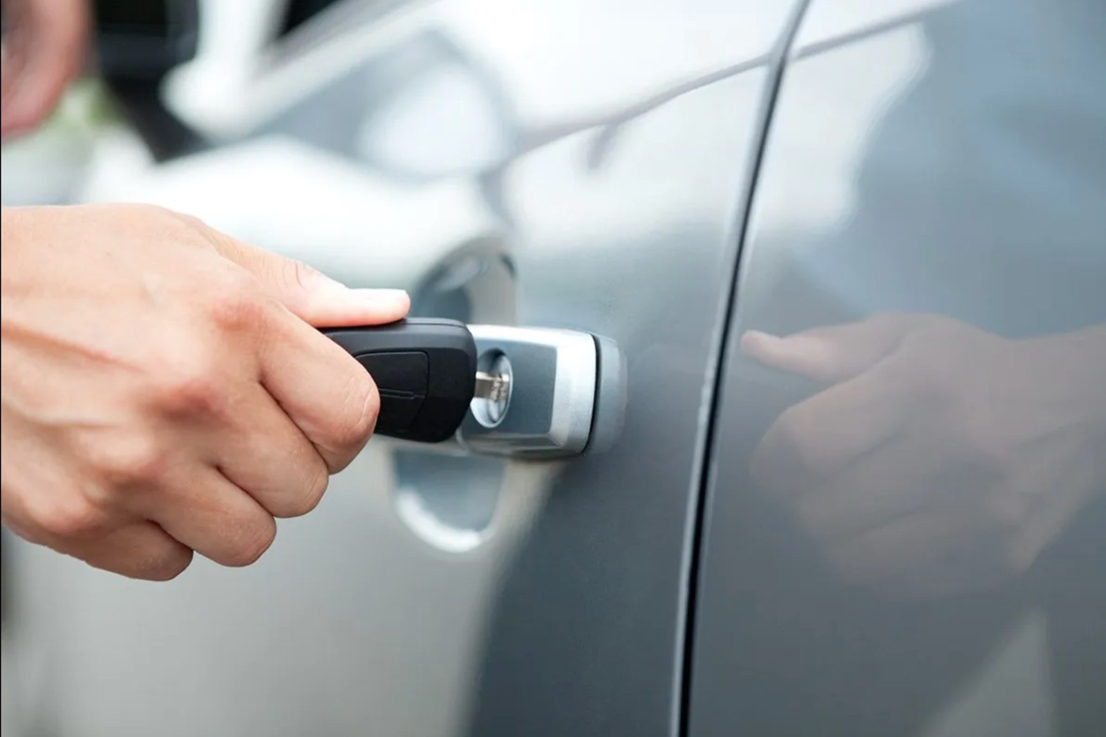 A transponder car key and fob at a vehicle's driver door